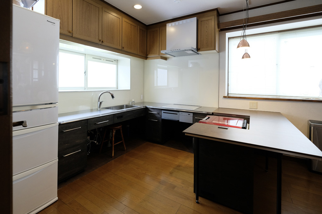 L型キッチンに電子レンジが納まるダイニングテーブル